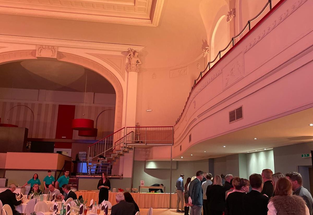 Blick in den Festsaal mit umlaufender Empore, Buffet und eingedeckten Tischen