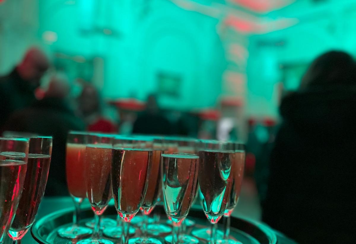 Tablett mit gefüllten Sektgläsern, im Hintergrund unscharf die Gäste in der Josephine Bar